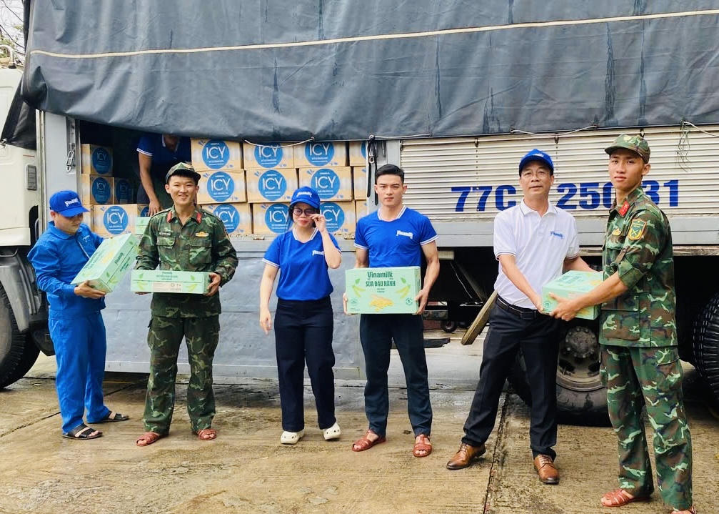 Anh Nguyễn Xuân Bình – Giám đốc Nhà máy Sữa Vinamilk Bình Định cùng cán bộ công nhân viên công ty trao tặng sản phẩm dinh dưỡng Vinamilk - Ảnh: Vi Nam