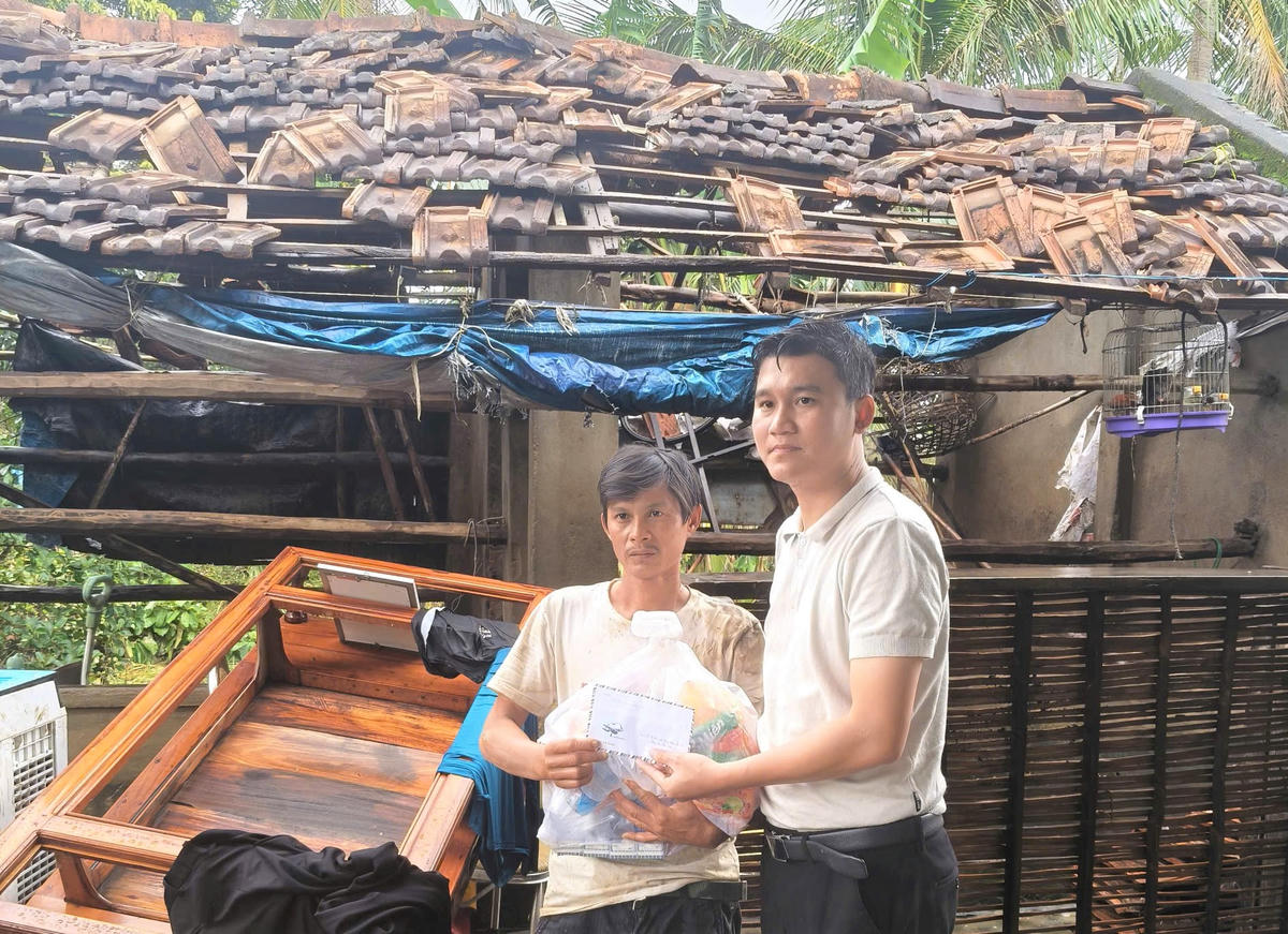 Anh Nguyễn Phong Lợi (áo trắng) hỗ trợ cho gia đình anh Lê Văn Rô. Ảnh: CV.