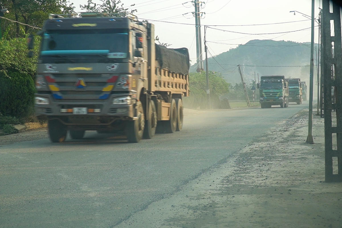 Một loạt xe tải đi qua đường dân sinh ở xóm Kim Sơn, sau đó rẽ vào QL217 kéo theo bụi bay mù mịt. Ảnh: Đình Minh