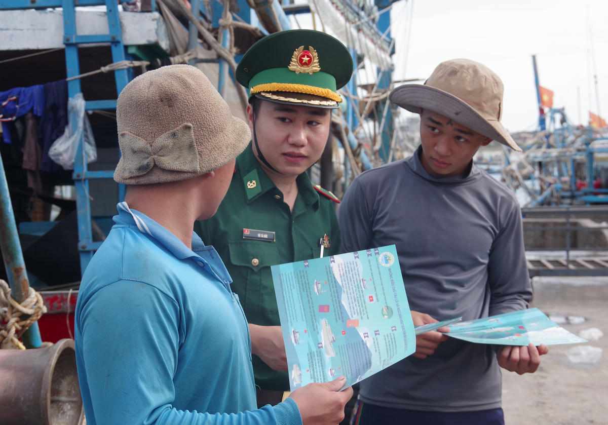 Phát tờ rơi tuyên truyền về công tác phòng, chống khai thác IUU cho ngư dân tại các khu vực công cộng, cảng cá, bến, bãi. Ảnh: Văn Danh.