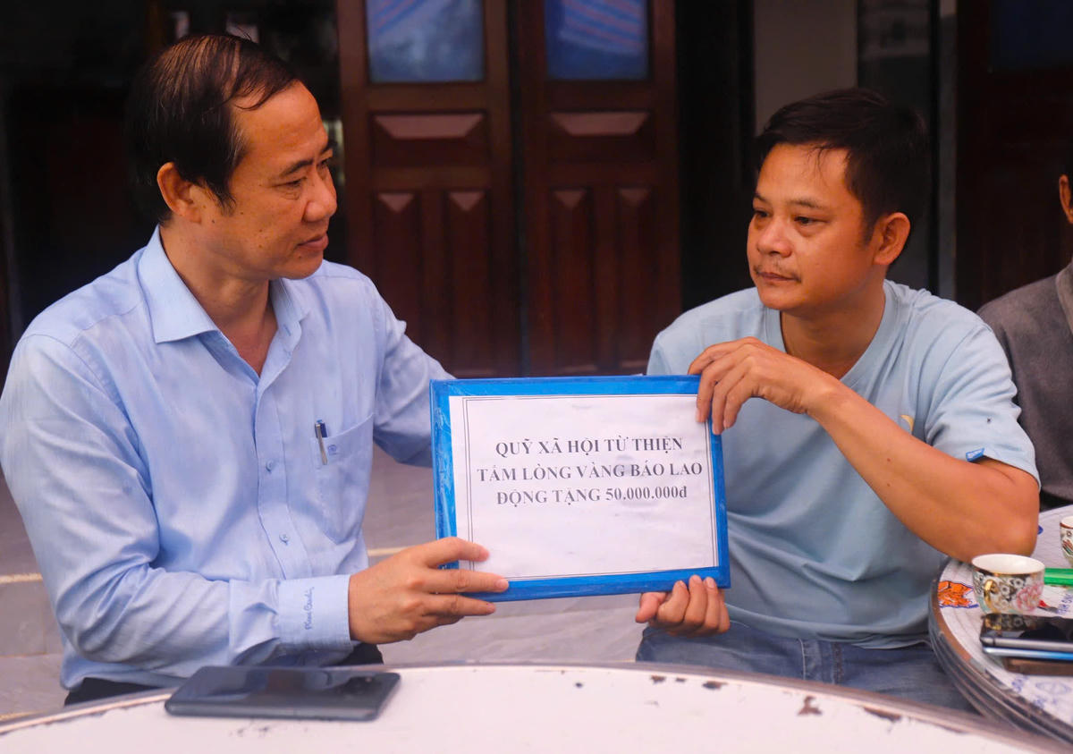 Ông Nguyễn Thái Học thay mặt Quỹ Xã hội từ thiện Tấm lòng vàng Báo Lao Động hỗ trợ gia đình 2 cháu nhỏ thiệt mạng trong đợt mưa lũ. Ảnh: TQ.