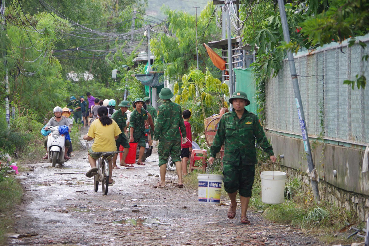 Cán bộ đồn Biên phòng cửa khẩu cảng Nha Trang dọn thu gom rác thải, khơi thông cống rãnh, khẩn trương làm sạch môi trường sau lũ.&nbsp;Ảnh: Văn Tân.