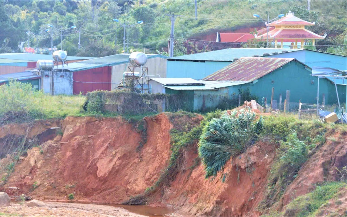 Suối Đăk Ter sạt lở tạo thành bờ vực cao hơn 2m nguy cơ sập đổ gây hư hỏng nhà dân. Ảnh: CV.