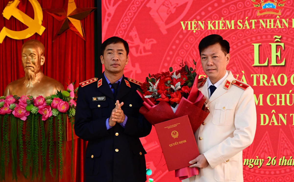 Phó Viện trưởng Viện KSND tối cao Nguyễn Duy Giảng trao quyết định, tặng hoa chúc mừng ông Lý Văn Huấn. Ảnh: Tuyenquang.gov.vn