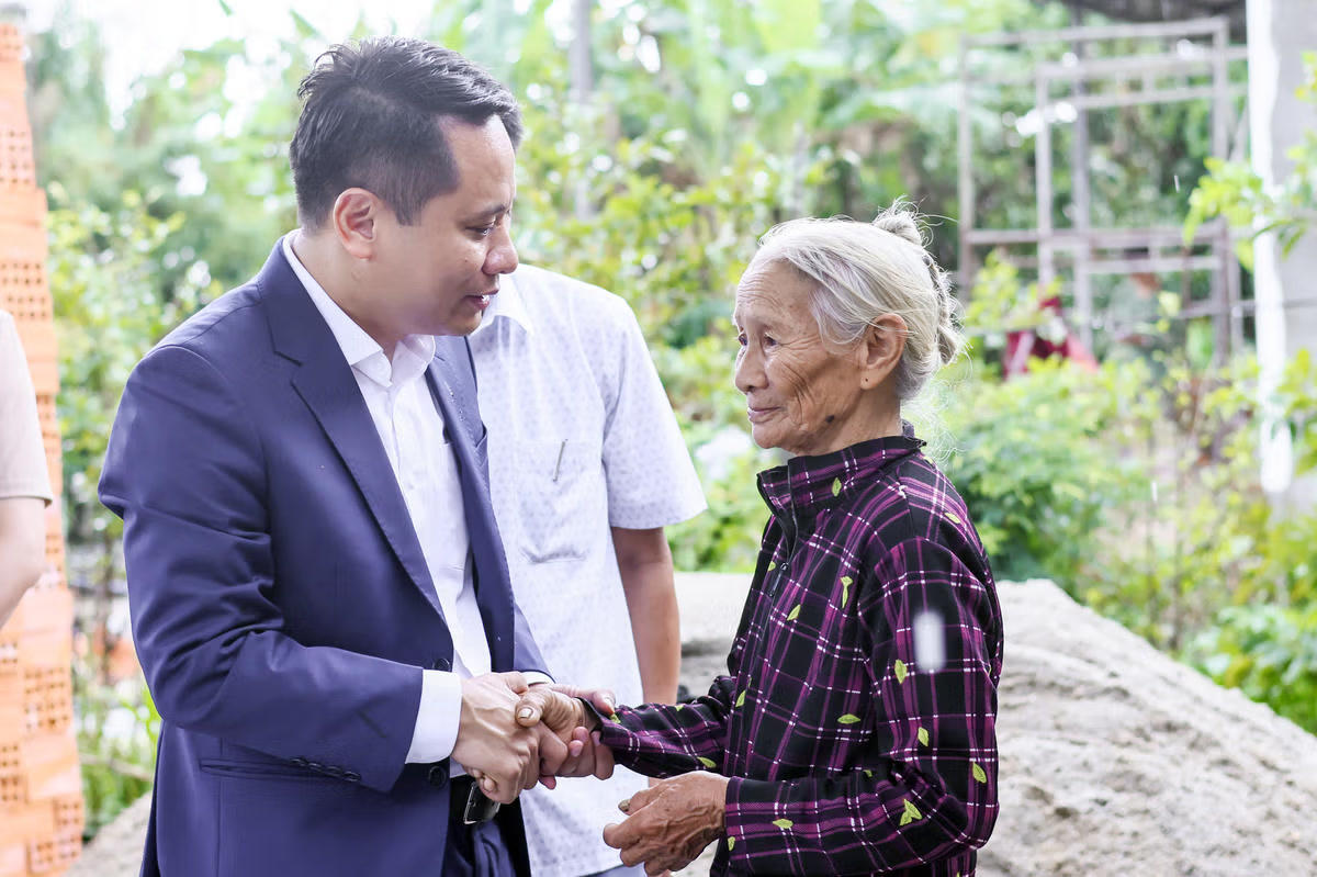 Nhà báo Trương Thành Trung, Tổng Biên tập Báo Đại đoàn kết thăm hỏi, động viên bà Lê Thị Hà. Ảnh: Quang Vinh.