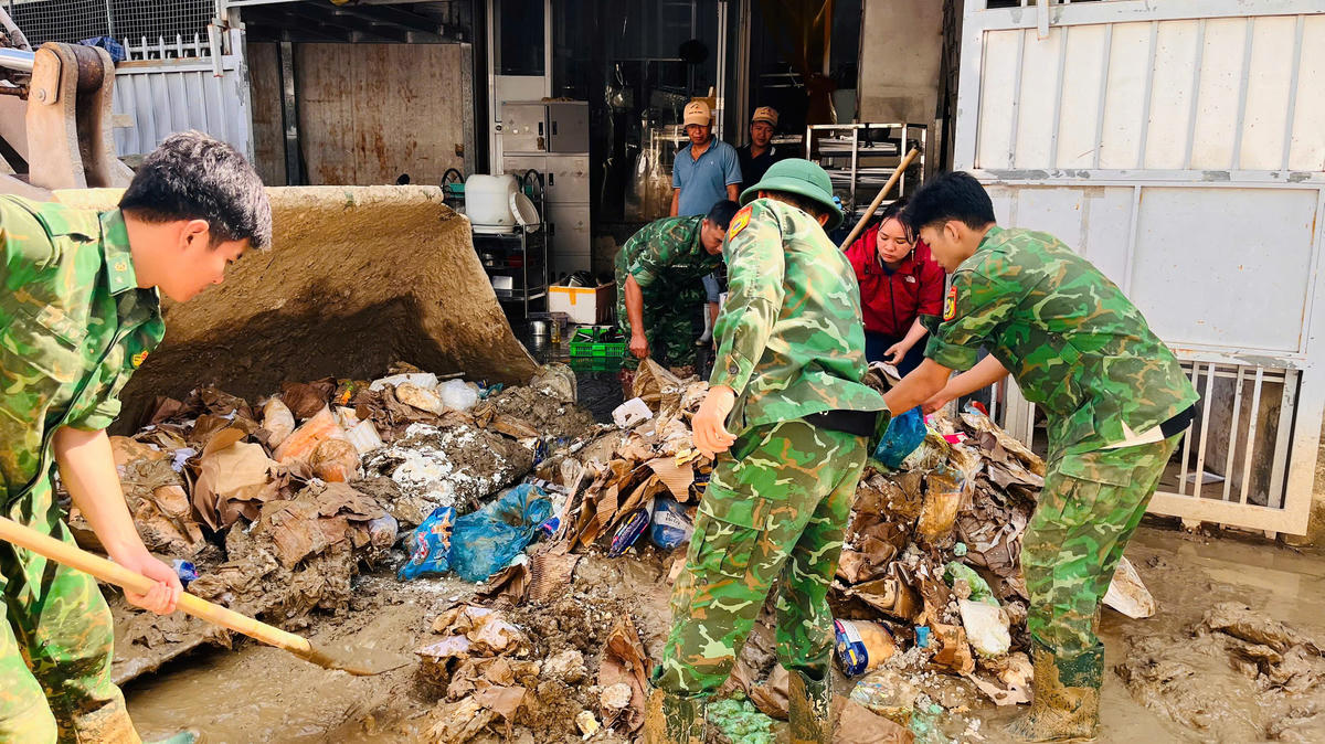 Bộ đội Biên phòng Khánh Hòa giúp dân dọn bùn đất, rác thải. Ảnh: Văn Tân.