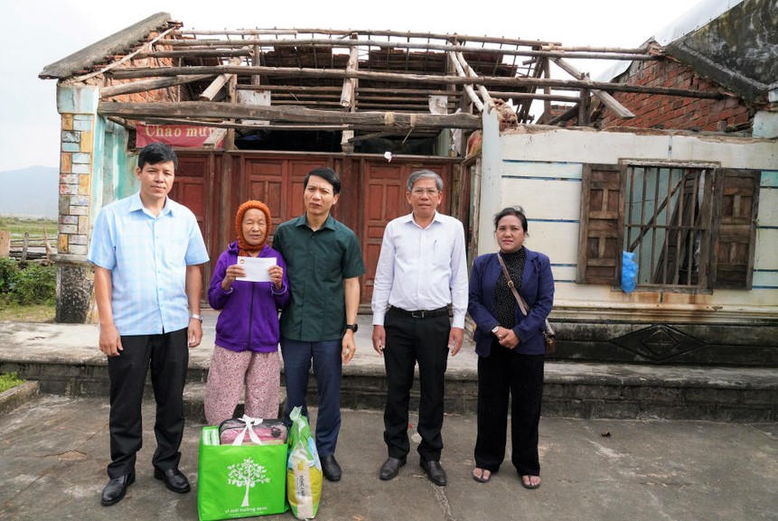 Ông Nguyễn Ngọc Lương (ở giữa) Phó Bí thư Tỉnh ủy, Chủ tịch Ủy ban MTTQ Việt Nam tỉnh Gia Lai tặng quà cho người dân xã Tuy Phước Đông bị hư hỏng nhà cửa mưa bão vừa qua. Ảnh: CV.
