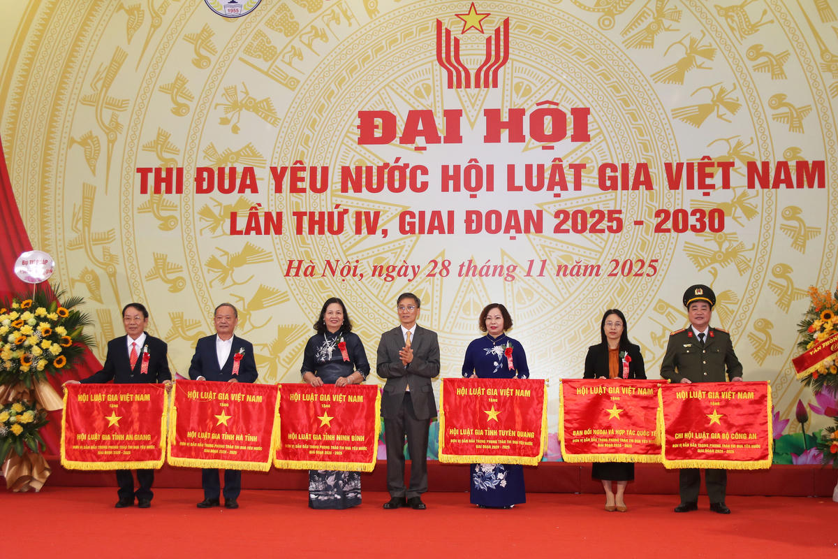 Chủ tịch Hội Luật gia Việt Nam Nguyễn Khánh Ngọc tặng Cờ thi đua cho các đơn vị. Ảnh: Tiến Đạt.