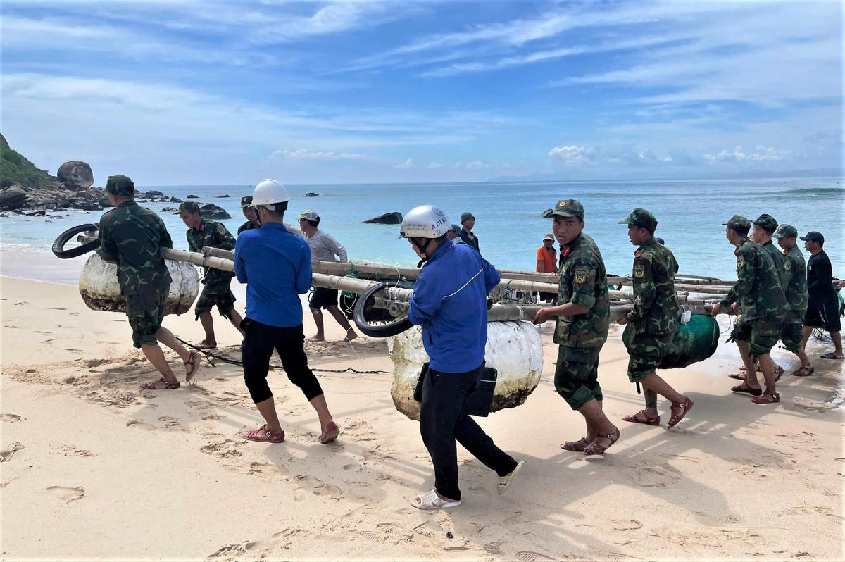 Lực lượng chức năng cùng người dân chuyển lồng bè lên bờ ứng phó bão số 15. Ảnh: CV.