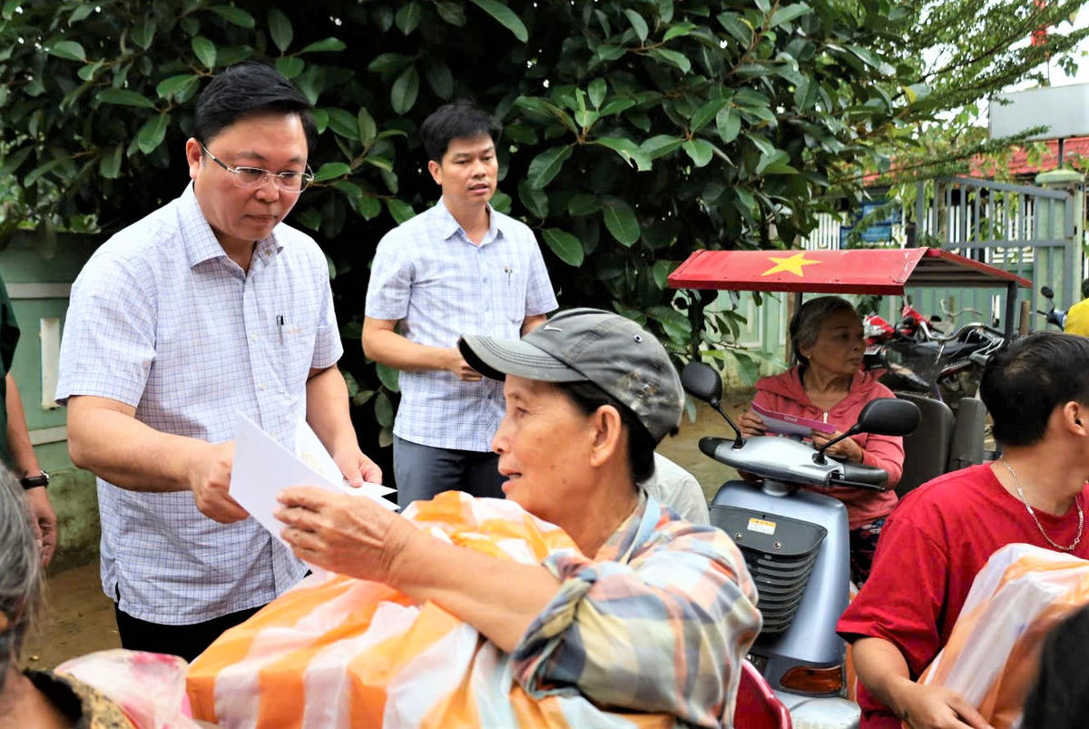 Chủ tịch Ủy ban MTTQ Việt Nam TP Đà Nẵng Lê Trí Thanh trao quà cho người dân vùng lũ. Ảnh: Chí Đại.