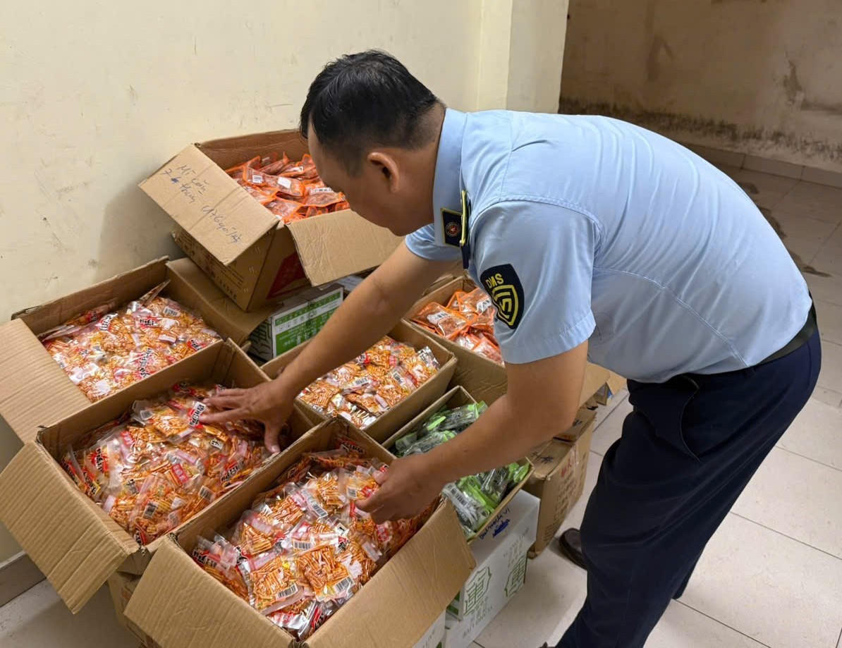 Cán bộ Đội QLTT số 11 kiểm tra lô bánh kẹo đóng gói không rõ nguồn gốc, xuất xứ, không nhãn hiệu. Ảnh: Đội QLTT số 11.