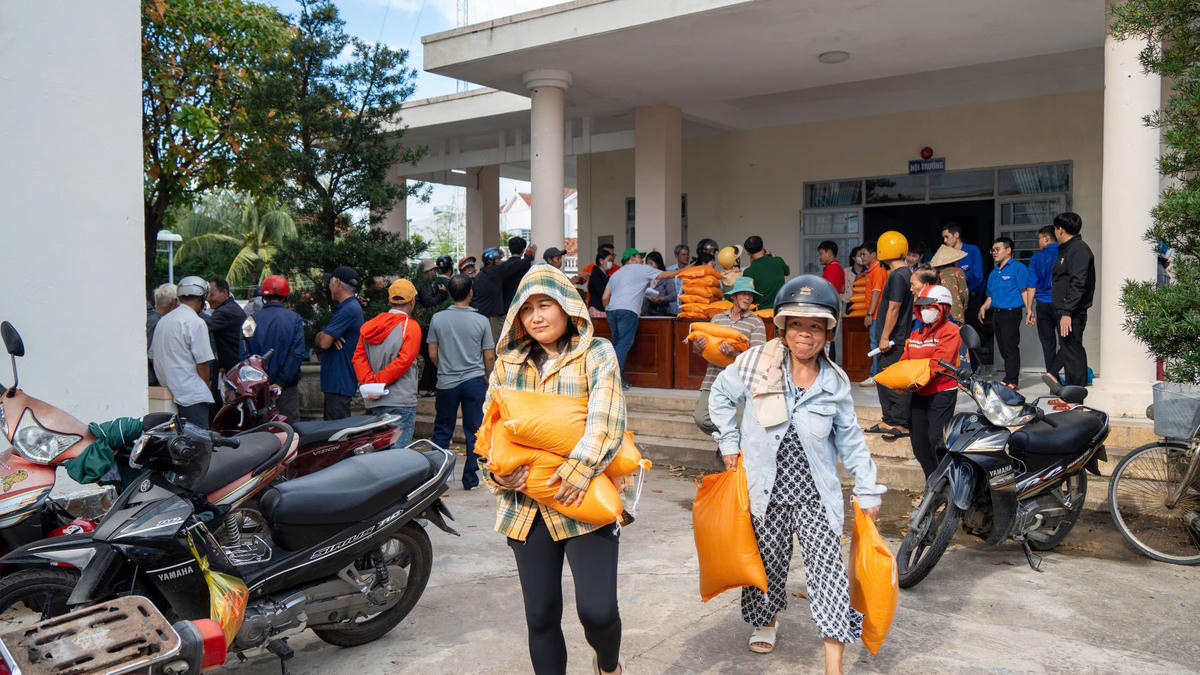 Người dân vùng lũ vui mừng vì những bao gạo được vận chuyển hàng trăm cây số tới và trao tận tay. Ảnh: Châu Phạm.