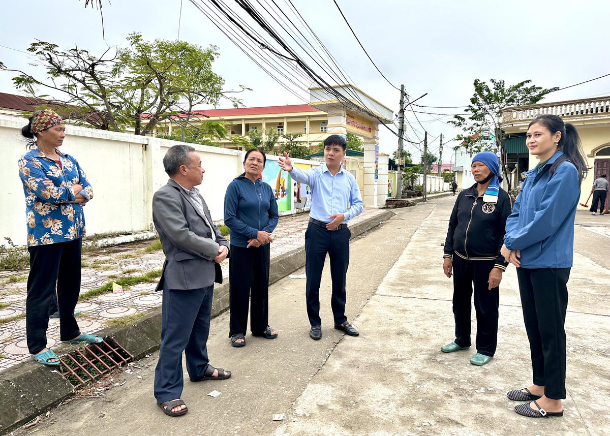 Lãnh đạo Ủy ban MTTQ Việt Nam phường Phong Cốc và bà Trần Thu Hà, Phó Bí thư Chi bộ, Trưởng Ban CTMT khu Cẩm Lũy tuyên truyền cho người dân về ý nghĩa của dự án&nbsp;cải tạo, nâng cấp đường Cửa Lũy. Ảnh: Ngọc Anh