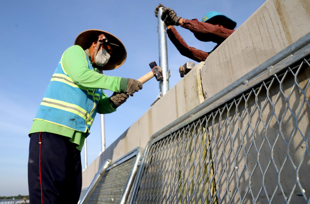 Mặc dù trời nắng to nhưng các công nhân tranh thủ hoàn thành nhiệm vụ. Ảnh Quốc Trung&nbsp;