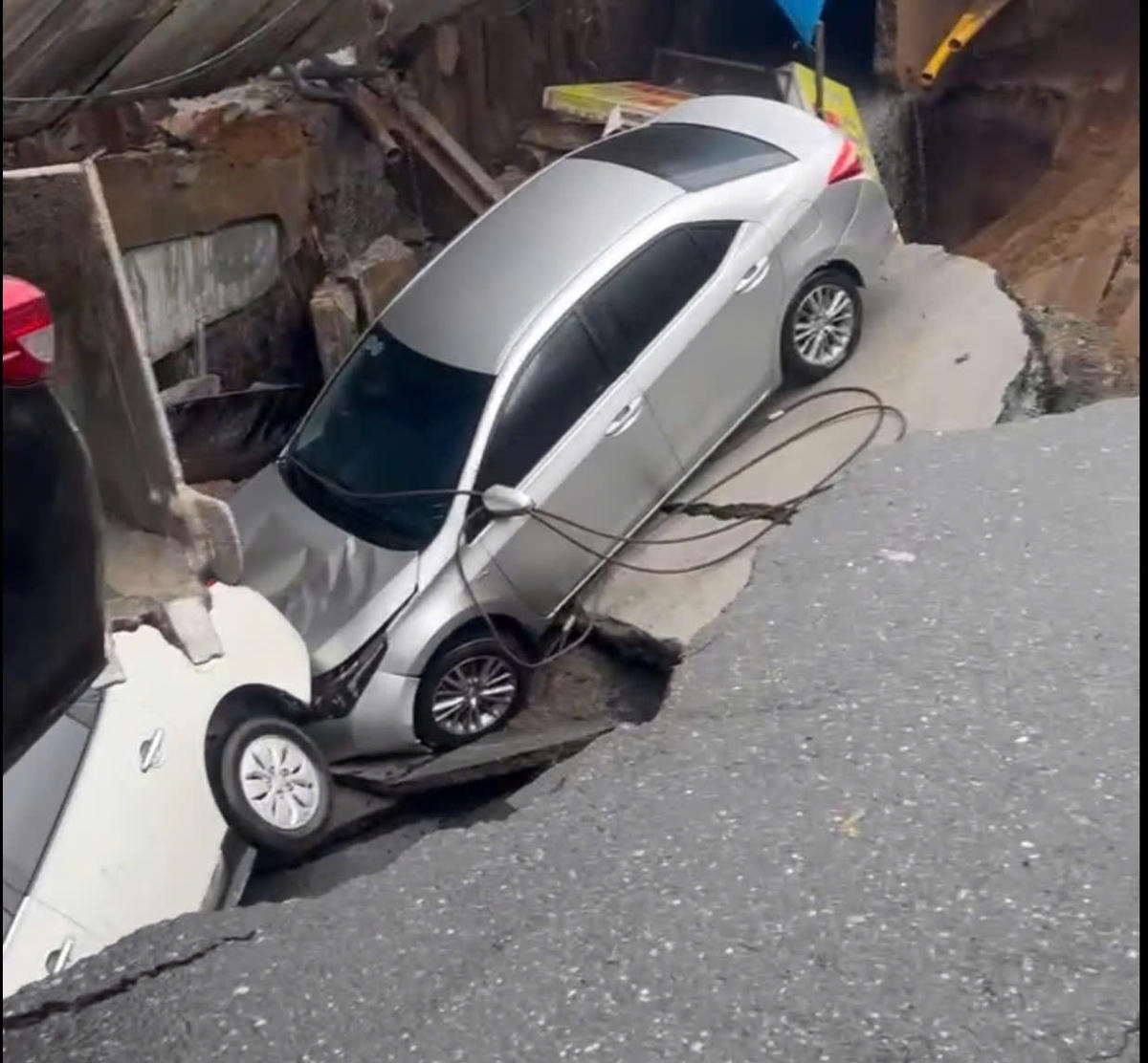 Ô tô bị "nuốt" xuống hố. Ảnh: Nguyễn Tú.