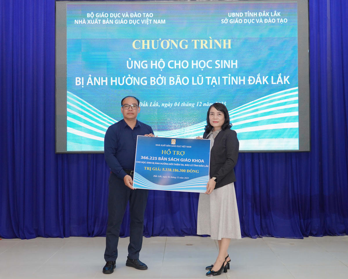 Ông Đặng Thanh Hải -  Phó Tổng Giám đốc NXBGDVN trao biển tặng sách giáo khoa cho bà Võ Thị Minh Duyên - Phó Giám đốc Sở GD-ĐT tỉnh Đắk Lắk.