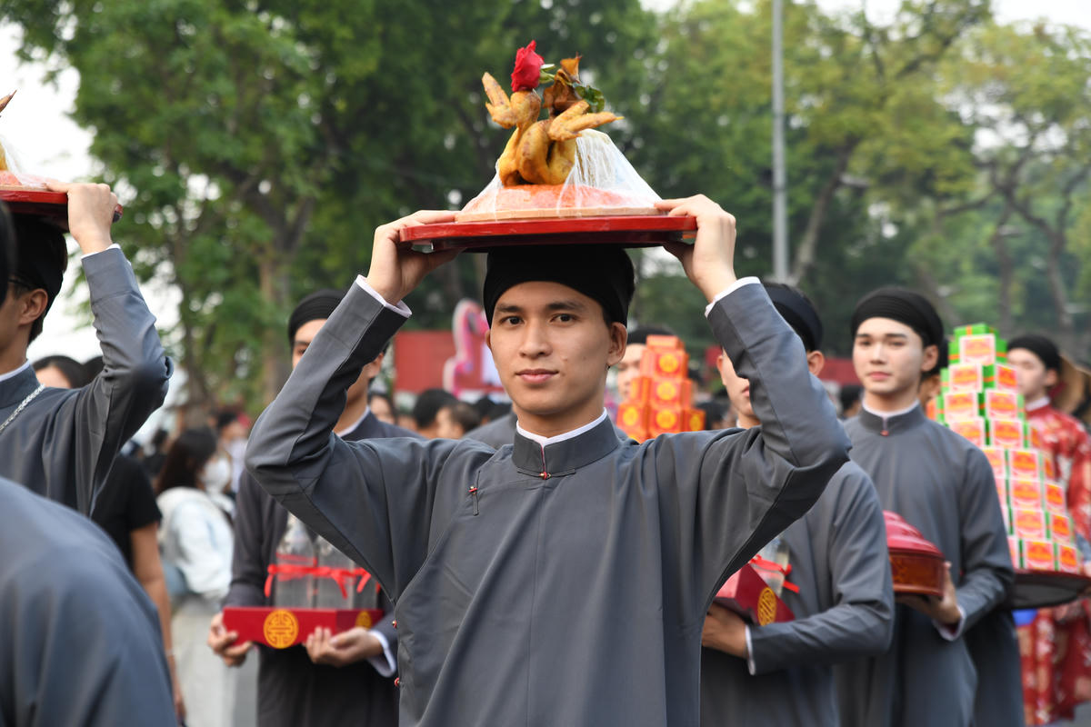 Chàng trai trong tà áo dài đội lễ. Ảnh: Phạm Sỹ.