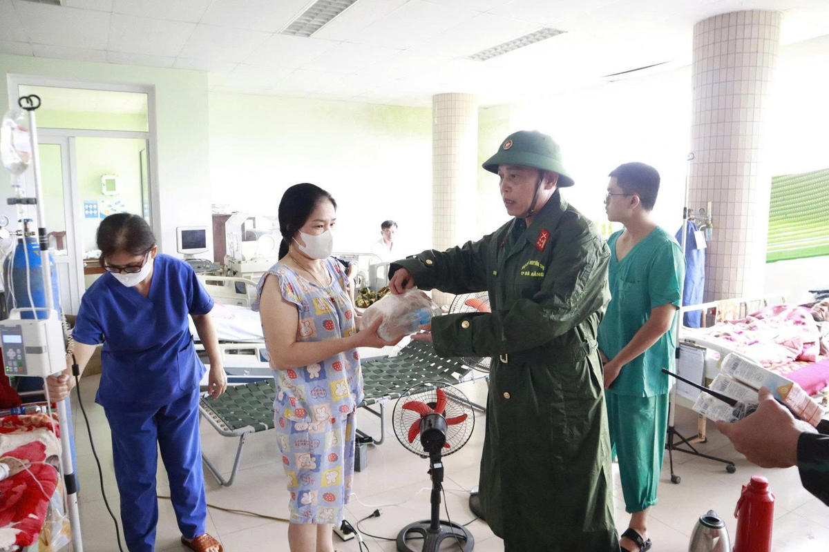 Đại tá Trần Hữu Ích, Chỉ huy trưởng Bộ CHQS TP Đà Nẵng thăm bệnh nhân ở vùng lũ phường Điện Bàn. Ảnh: CV.