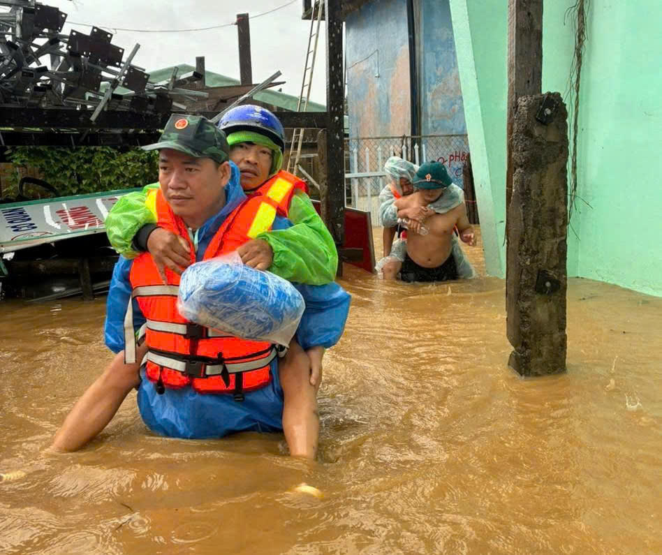 Chiến sĩ của Bộ CHQS TP Đà Nẵng cõng người dân vùng ngập lũ đến nơi an toàn. Ảnh: CV