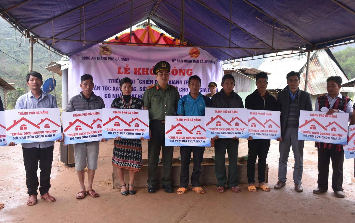 Lãnh đạo Công an TP Đà Nẵng trao bảng tượng trưng hỗ trợ xây nhà cho người dân bị thiệt hại mưa lũ vừa qua. Ảnh: CV.