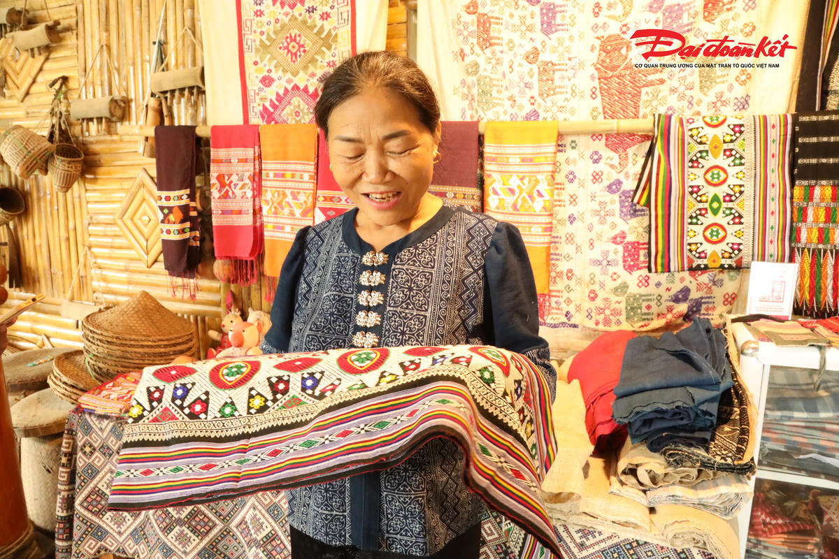 Nghệ nhân Sầm Thị Bích trú bản Hoa Tiến, xã Châu Tiến (Nghệ An) với sản phẩm dệt thổ cầm do mình tạo ra. Ảnh: ĐB