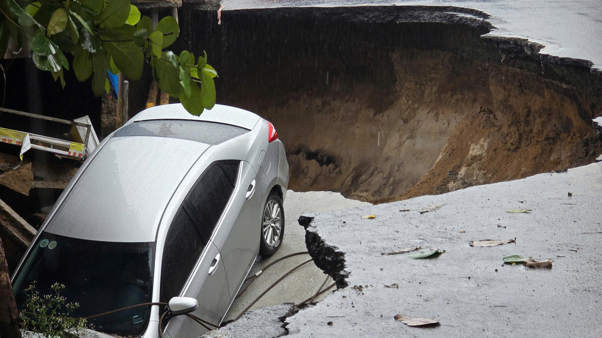 Ô tô bị sụt lún xuống hố. Ảnh: Nguyễn Tú.