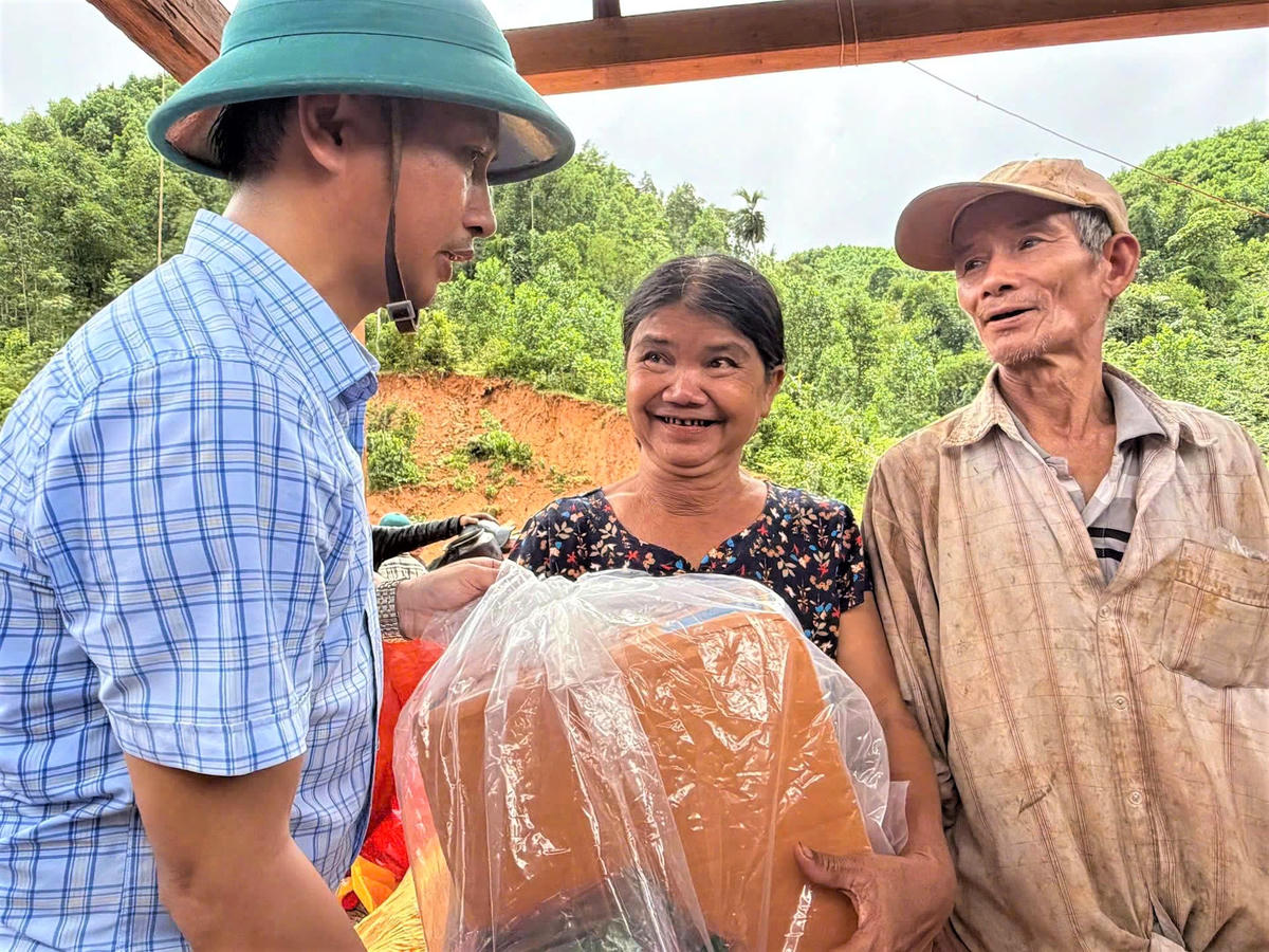 Ông Nguyễn Hồng Lai, Bí thư Đảng ủy xã Trà Tân thăm hỏi, tặng quà bà Nguyễn Thị Thương. Ảnh: CV.