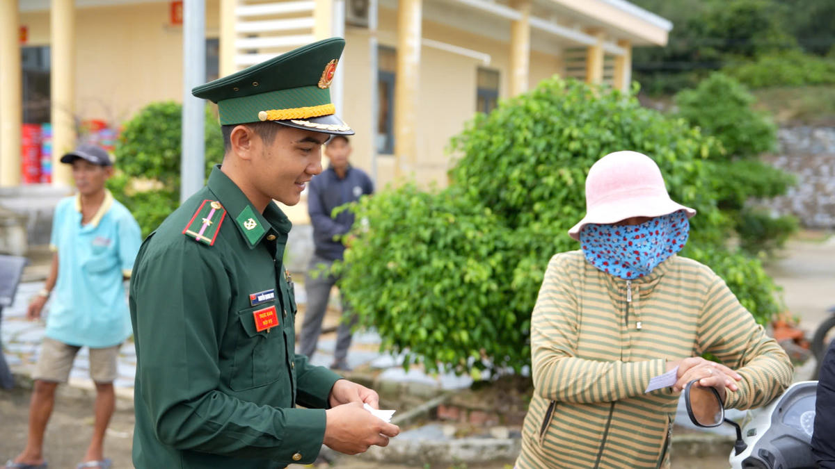 Những người lính biên phòng tận tình hướng dẫn từng thủ tục, hỗ trợ từng hộ dân. Ảnh: Bảo Lâm.