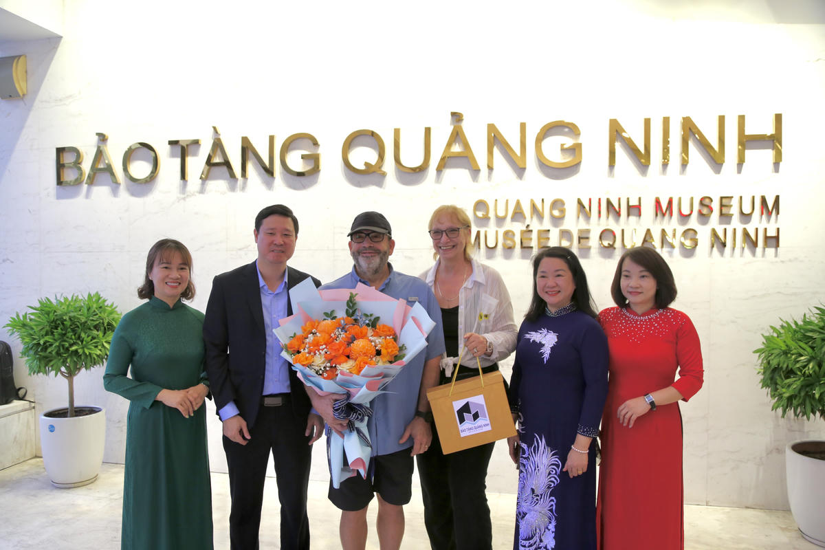 Ông Đỗ Quyết Tiến, Giám đốc Bảo tàng - Thư viện Quảng Ninh tặng hoa và quà lưu niệm cho vị khách thứ 1 triệu  của Bảo tàng Quảng Ninh trong năm 2025. Ảnh: Ngọc Anh.