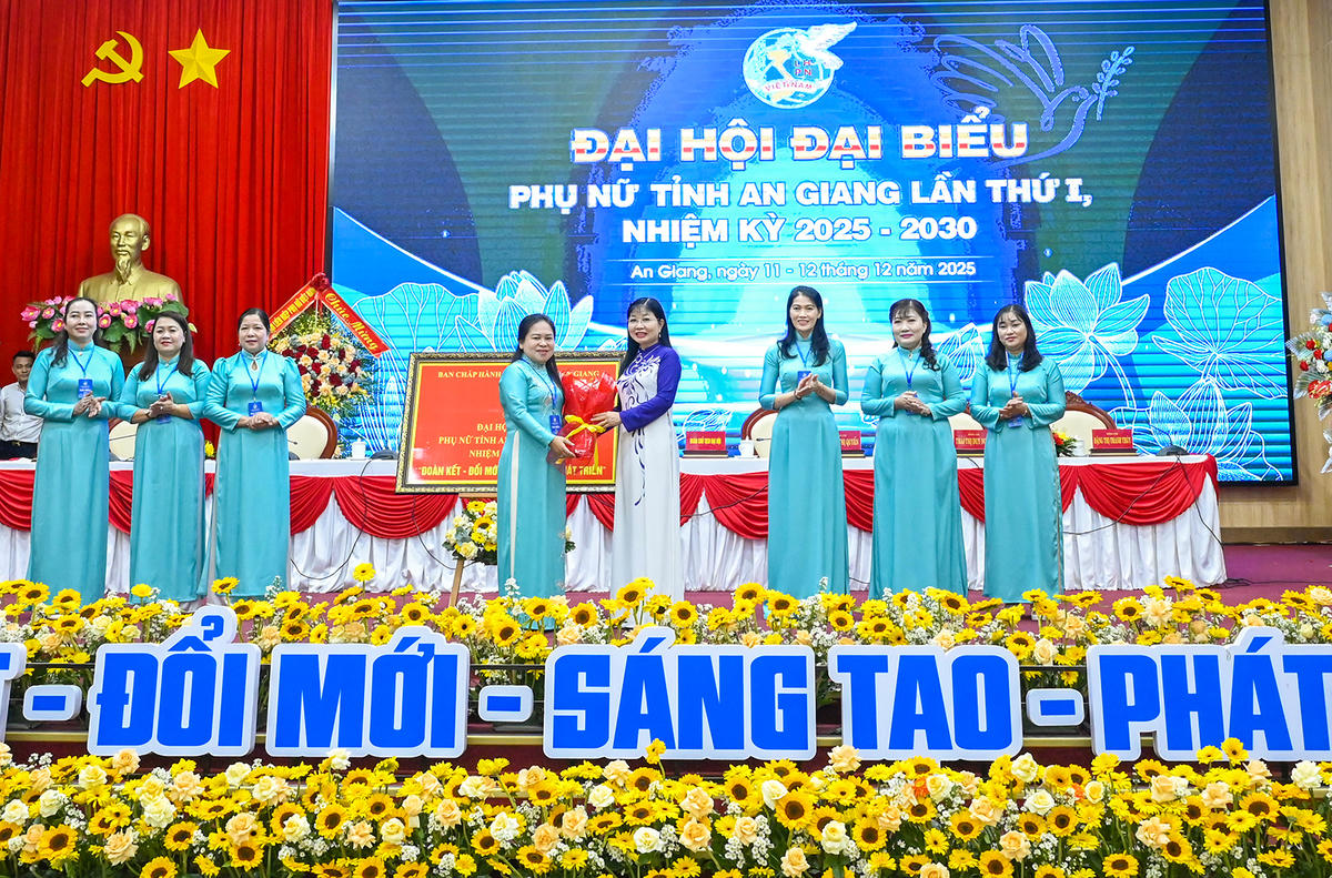 Phó Bí thư Tỉnh ủy, Chủ tịch Ủy ban Mặt trận Tổ quốc Việt Nam tỉnh An Giang Trần Thị Thanh Hương tặng bức trướng chúc mừng đại hội. Ảnh Nguyễn Minh.