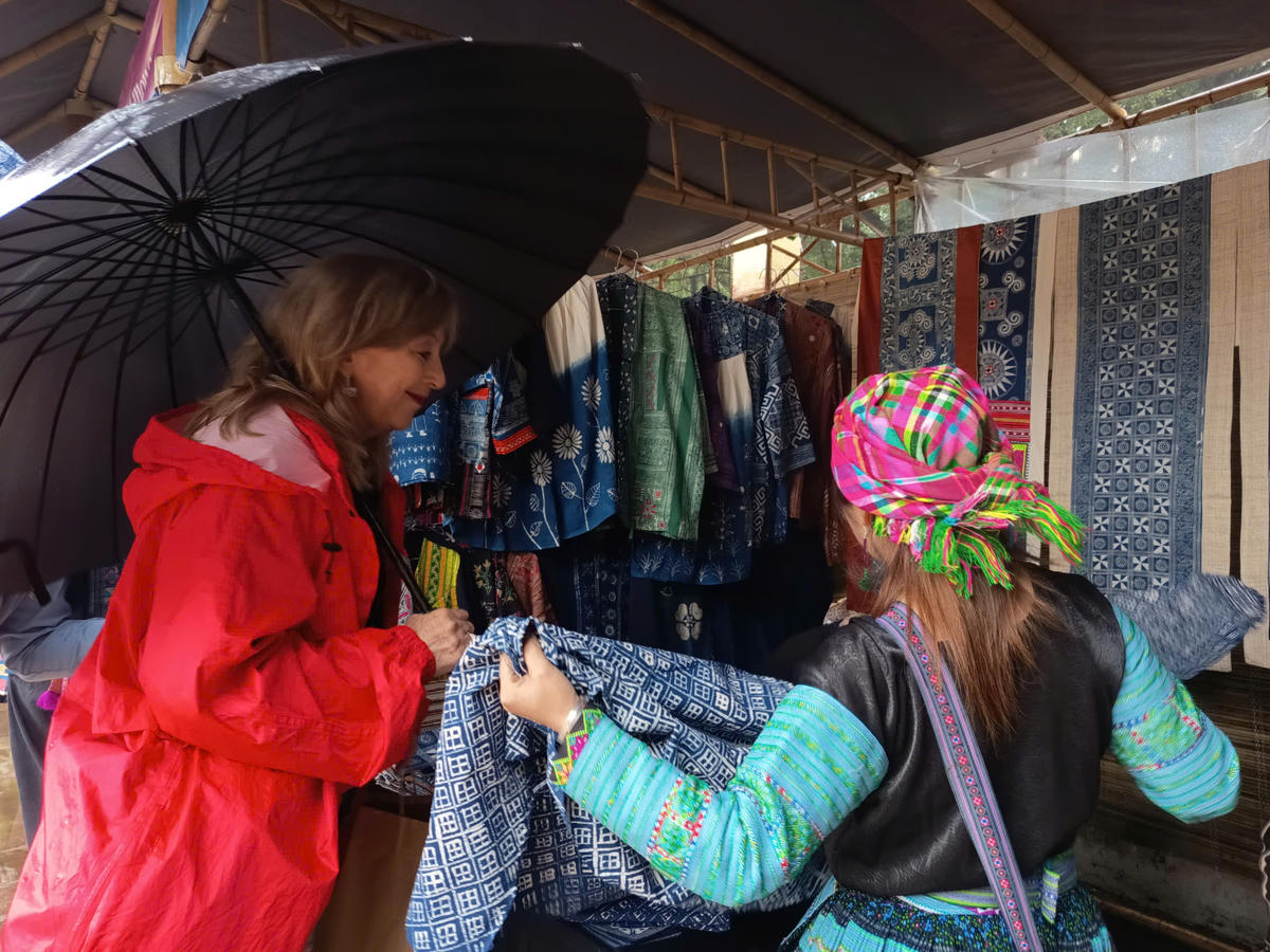 Du khách quốc tế thích thú với những thổ cẩm do người Mông tạo ra và đã mua để làm quà. Ảnh: Phạm Sỹ.