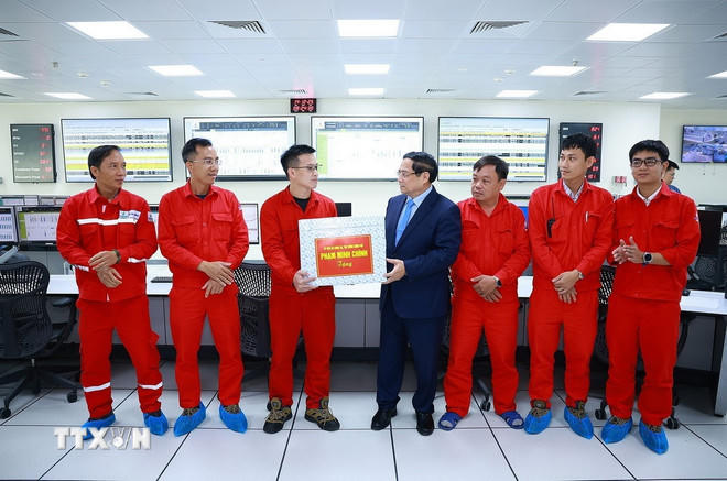 Thủ tướng Phạm Minh Chính tặng quà cho kỹ sư, chuyên gia điều hành Nhà máy điện LNG Nhơn Trạch 3 và 4. (Ảnh: Dương Giang/TTXVN).