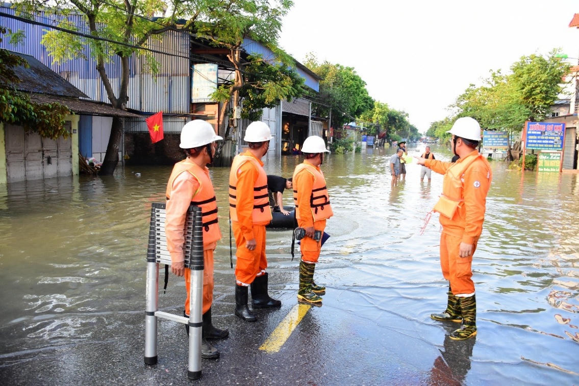 Công nhân EVNHANOI kiểm tra tình trạng lưới điện nơi ngập úng tại khu vực Sóc Sơn.
