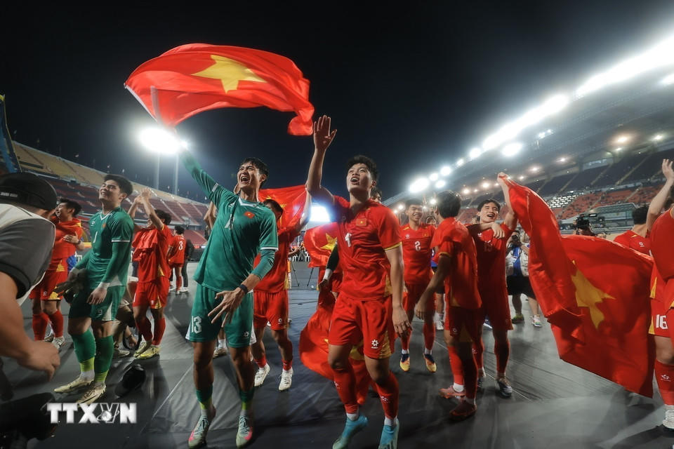 Các cầu thủ U22 Việt Nam hân hoan chia vui với người hâm mộ trên sân Rajamangala. (Ảnh: Minh Quyết/TTXVN).