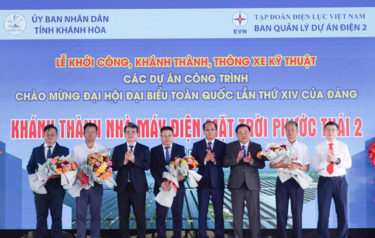 Lãnh đạo tỉnh Khánh Hòa cùng đại diện Tập đoàn Điện lực Việt Nam tặng hoa cho đơn vị thi công. (ảnh X.H)
