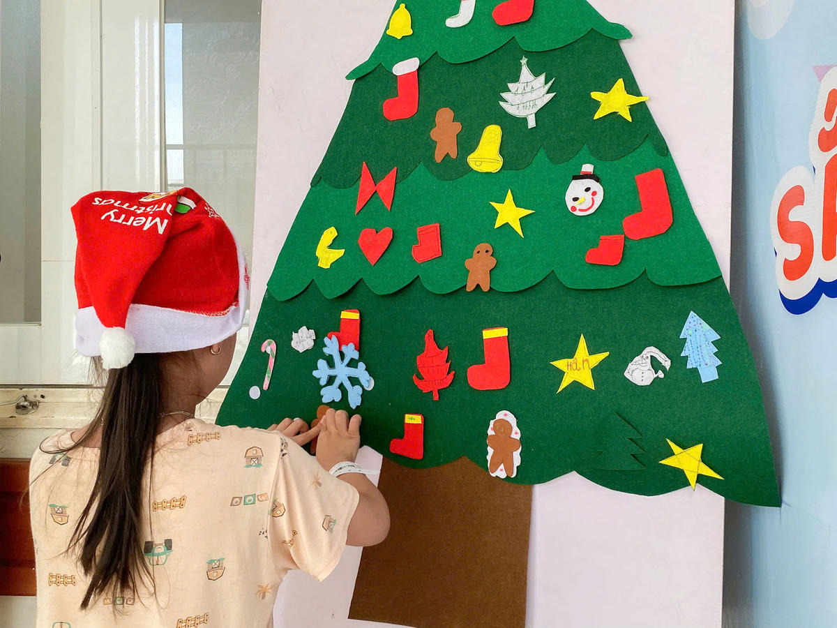 Các bé trang trí cây thông Noel. Ảnh: M.T