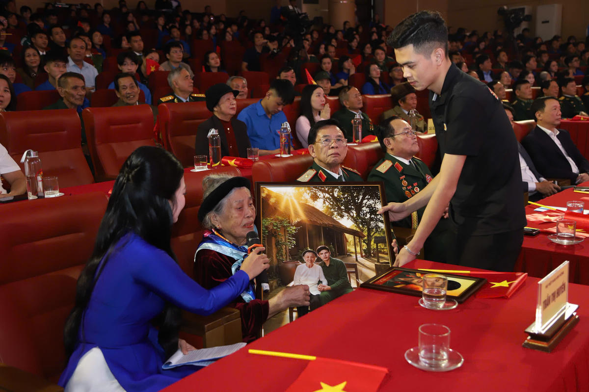 Đại diện nhóm Skyline trao tặng Mẹ Việt Nam anh hùng Trần Thị Huyến bức ảnh phục dựng mẹ và con trai. Ảnh: HN.