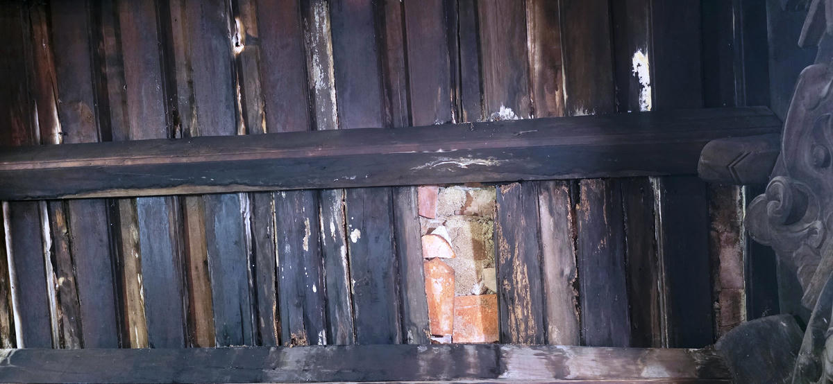 Bên trong phần mái, nhiều nơi rui, mè bị mục nát, tụt ngói gây tình trạng thấm dột... ảnh: Nguyễn Chung.