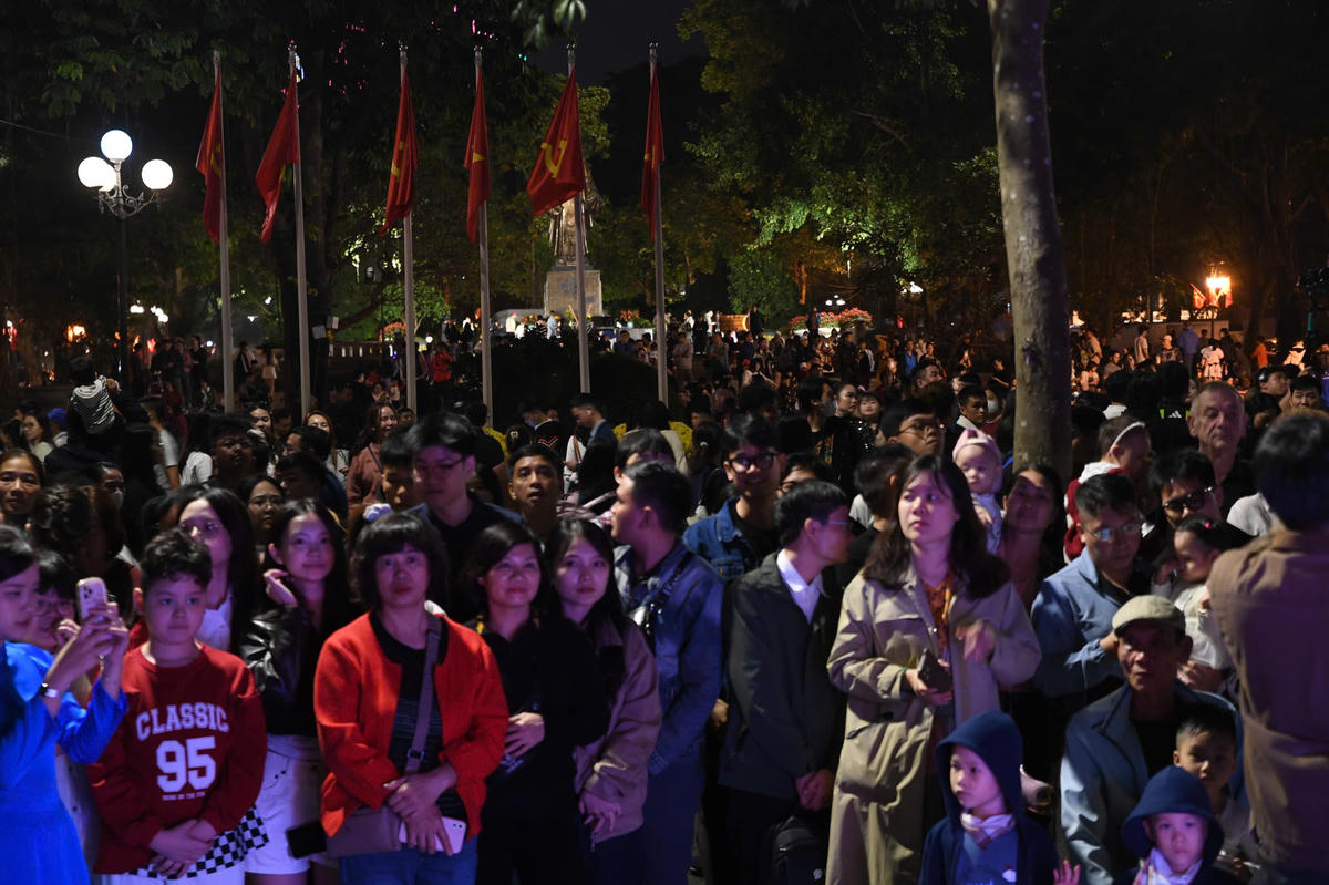 Người dân và du khách bên hồ Gươm, tận hưởng bữa tiệc ánh sáng đặc sắc giữa lòng Thủ đô. Ảnh: Phạm Sỹ.