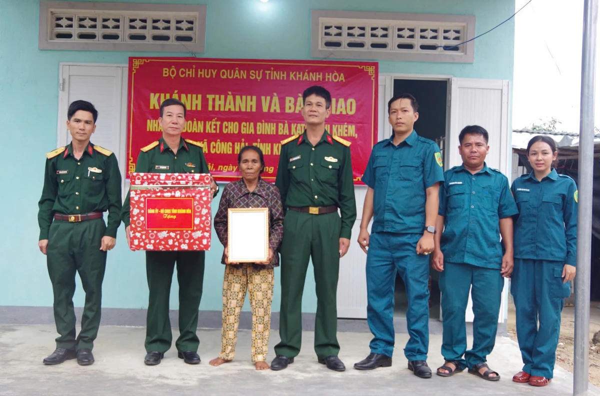 Đại diện Bộ Chỉ huy Quân sự tỉnh Khánh Hòa trao quyết định bàn giao nhà Đại đoàn két và quà cho hộ bà Khém. (ảnh CTV)