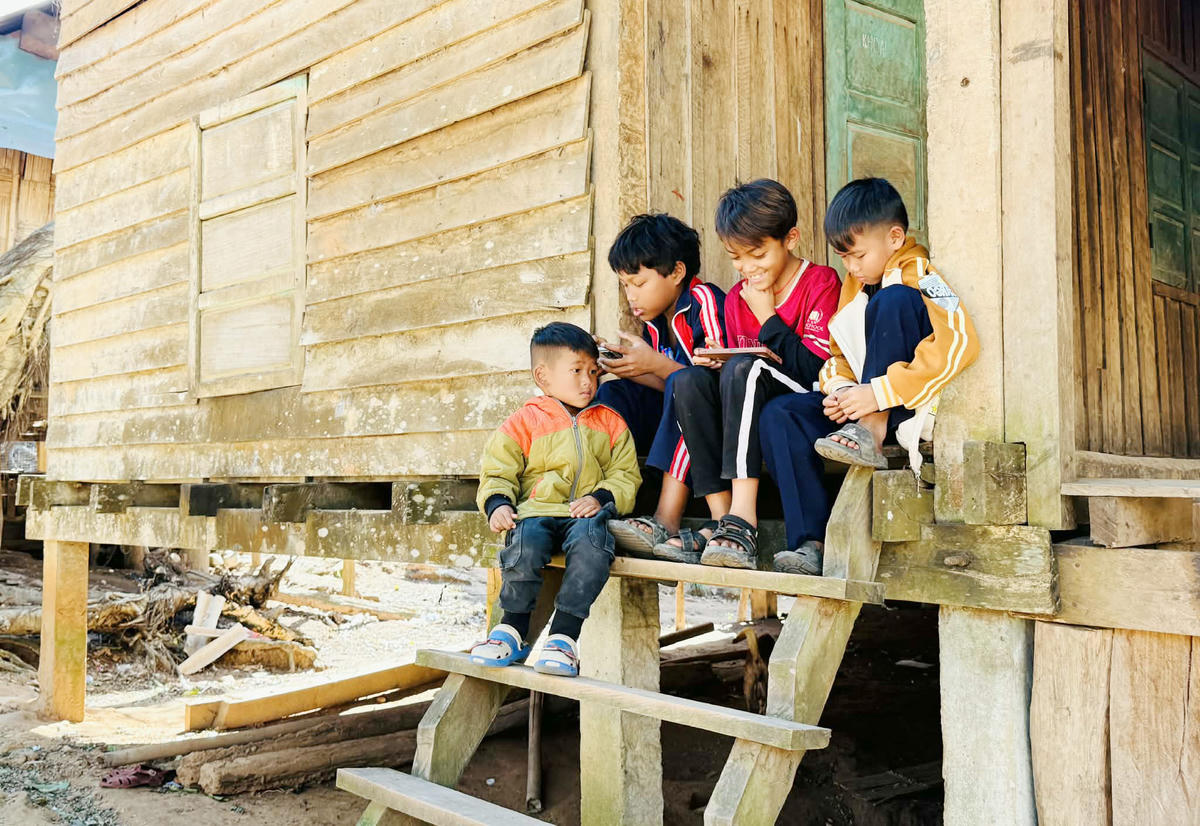Trẻ em người Bru – Vân Kiều ở xã Thượng Trạch sử dụng điện thoại thông minh.