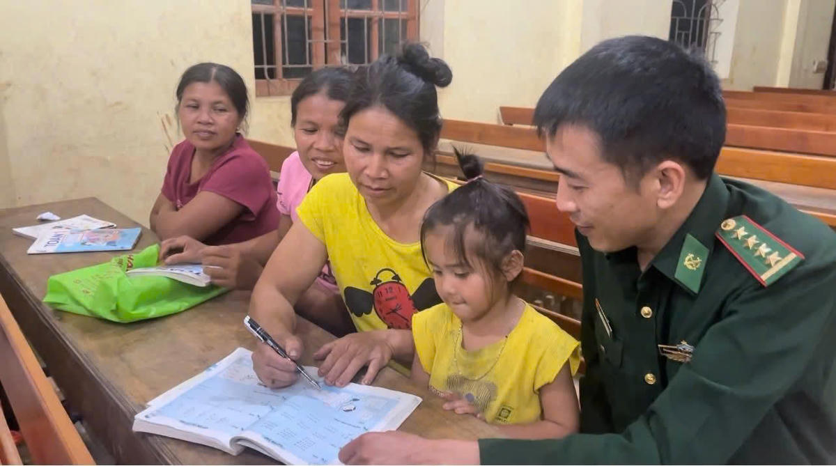 Đại úy Nguyễn Kim Trọng dạy chữ cho bà con trong bản. Ảnh: N.C.