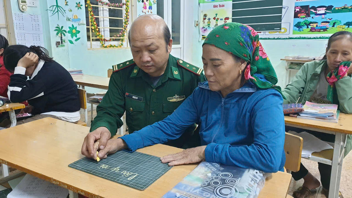 Thầy Cự Bá Pó cầm tay dạy học viên viết tên mình. Ảnh: NVCC