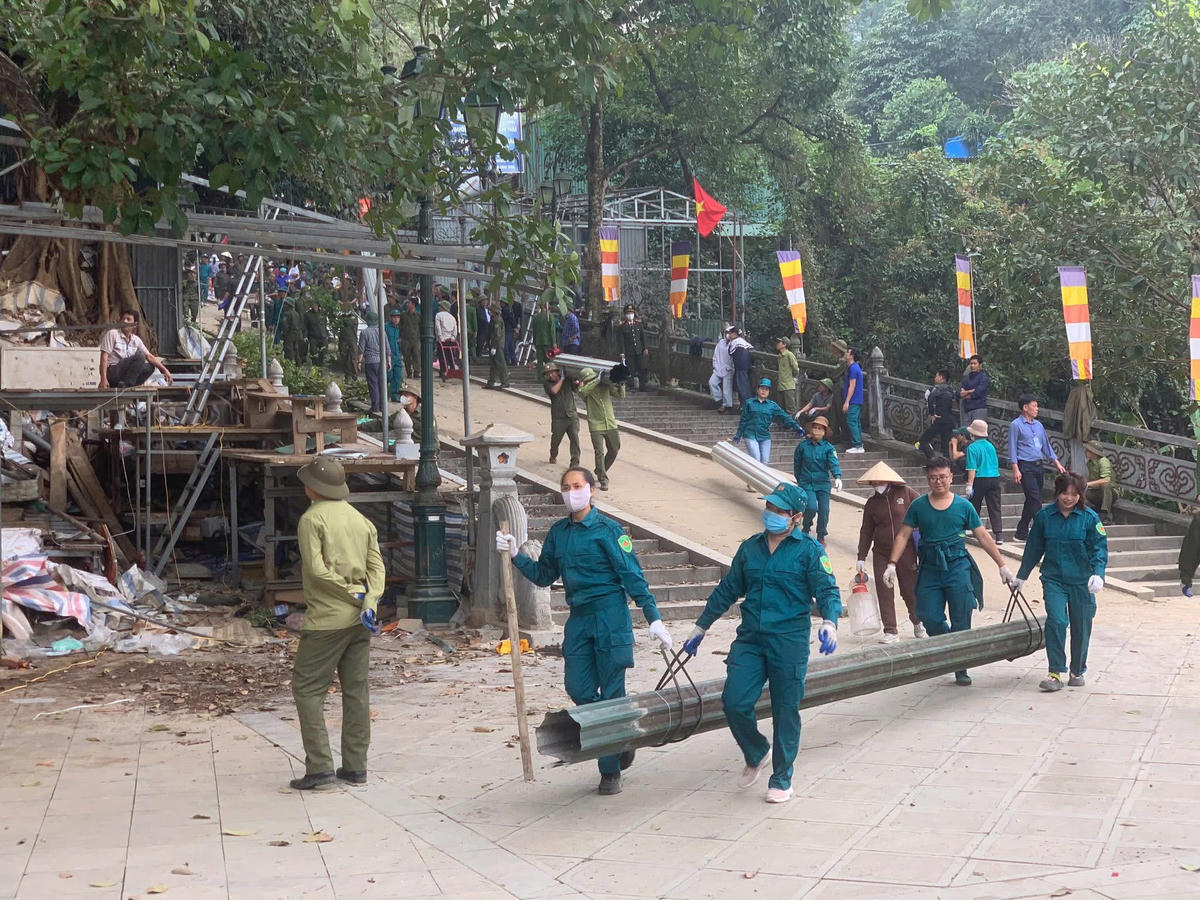 Lực lượng dân quân tích cực hỗ trợ nhân dân di chuyển hàng hóa, vật liệu ra khỏi khu vực. Ảnh: BT