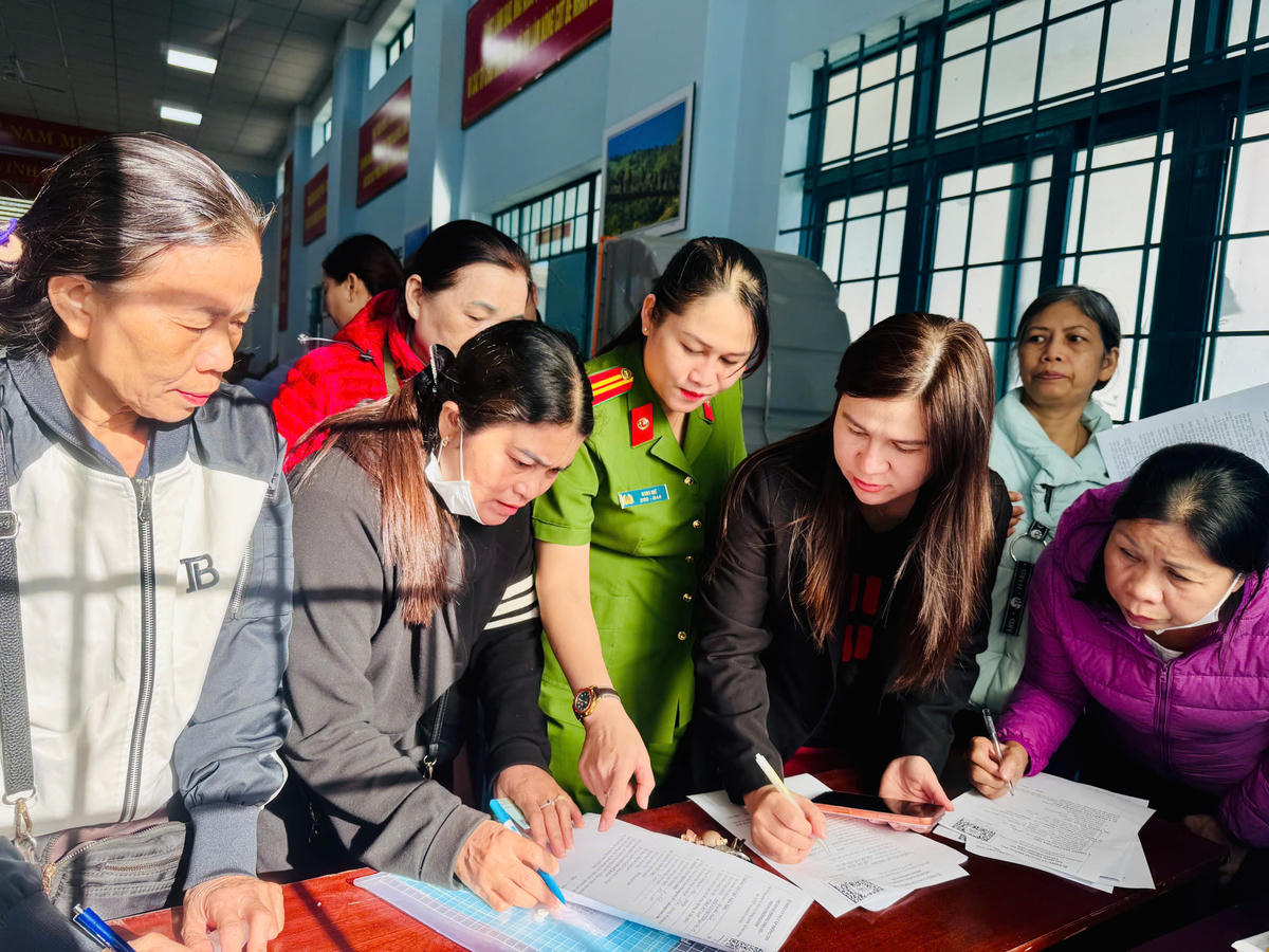 Công an phường Ea Cao hướng dẫn cho các hộ kinh doanh thực hiện các thủ tục đăng kí tạm trú. Ảnh: Thanh Nga.