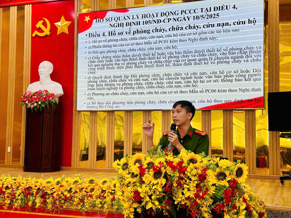 Thượng úy Hà Khắc Bá, cán bộ Cảnh sát khu vực đang tuyên truyền phổ biến các nội dung cho các hộ kinh doanh. Ảnh: Thanh Nga.