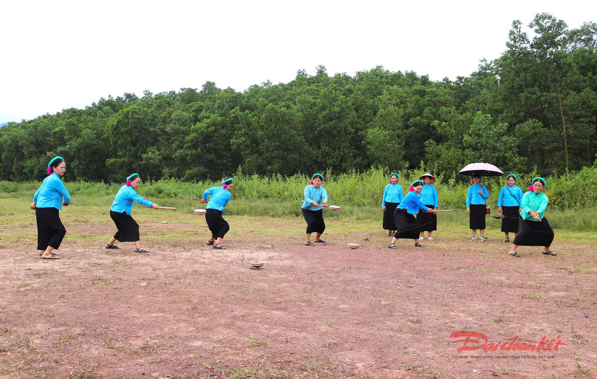 Phụ nữ Sán Chỉ ở Quảng Tân chơi con quay. Ảnh: Nguyễn Quý.