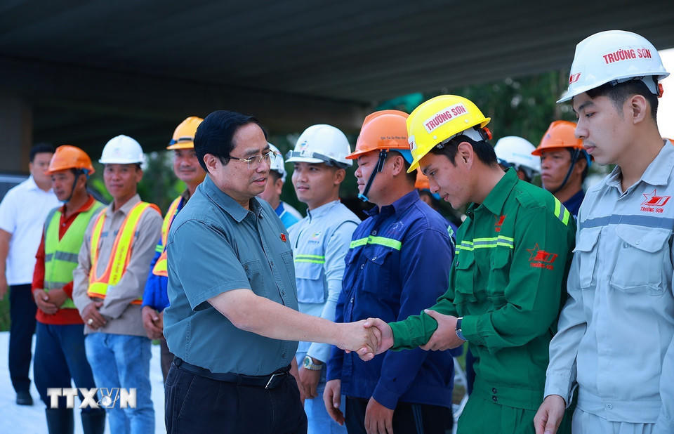 Thủ tướng Phạm Minh Chính với kỹ sư, công nhân thi công dự án cao tốc Châu Đốc-Cần Thơ-Sóc Trăng. (Ảnh: Dương Giang/TTXVN).
