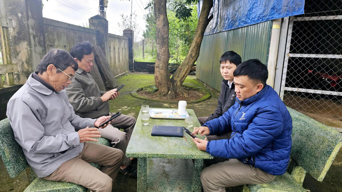 Thành viên Tổ công nghệ số cộng đồng thôn Đại Đồng Nhất hướng dẫn người dân cài đặt các ứng dụng tiện ích trên điện thoại thông minh - Ảnh: T.T