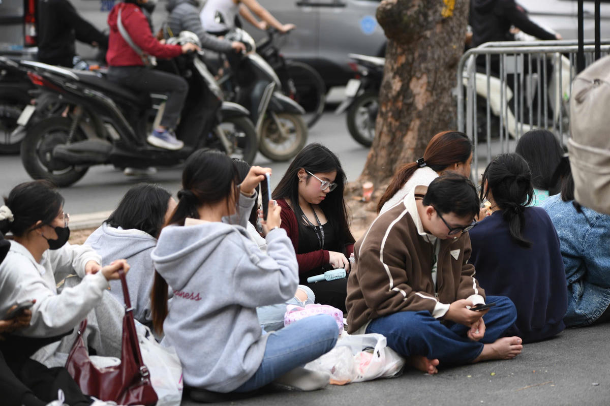 Nhiều nhóm bạn trẻ mang theo đồ ăn nhẹ, nước uống, xếp hàng từ sớm để “giữ chỗ”, chọn được góc nhìn ưng ý nhất cho đại tiệc đếm ngược. Ảnh: Phạm Sỹ.